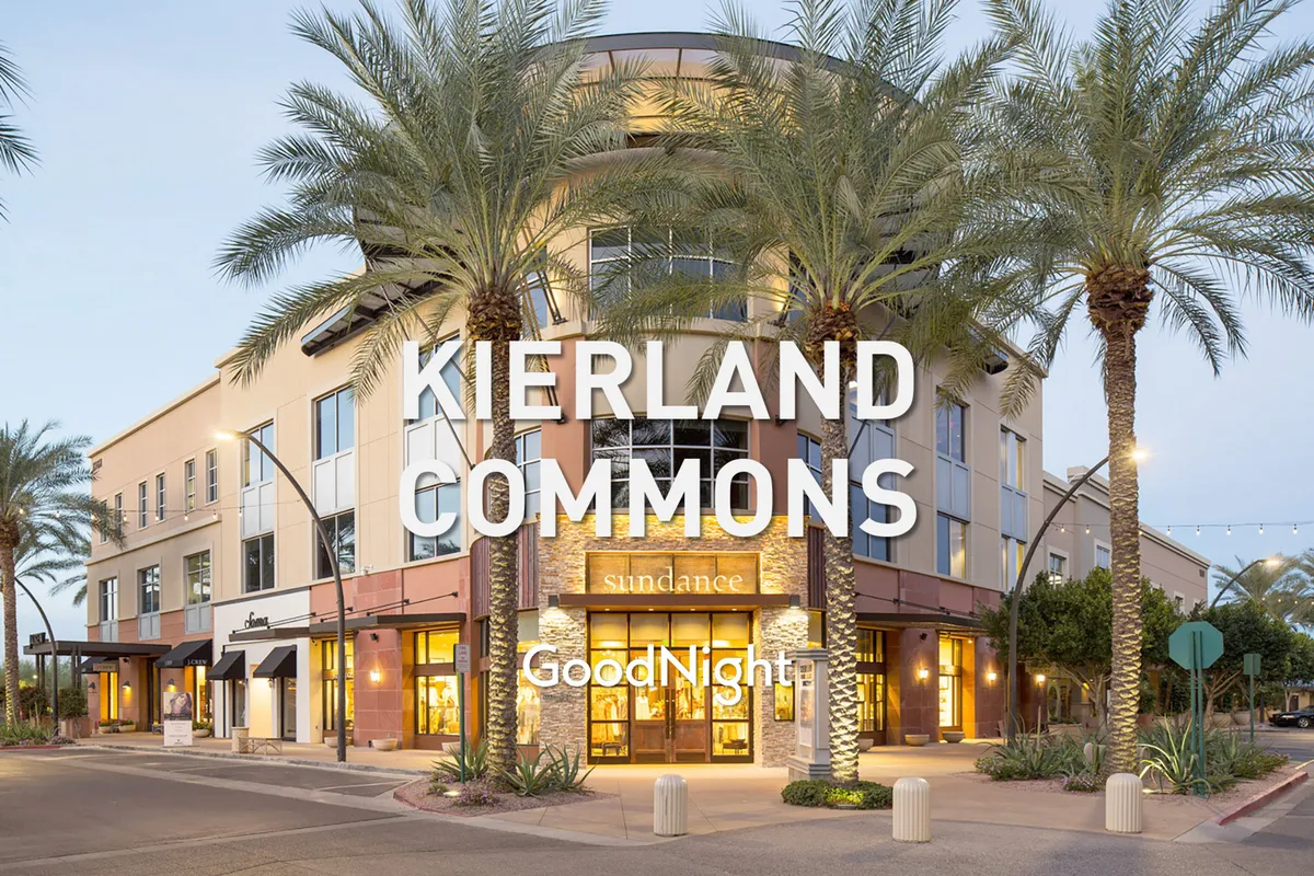 A vibrant exterior plaza with palm trees, the building facade, and event-style signage, suggesting an upscale shopping or dining district. The scene is active yet refined, hinting at nearby attractions such as Scottsdale Quarter or Kierland Commons.