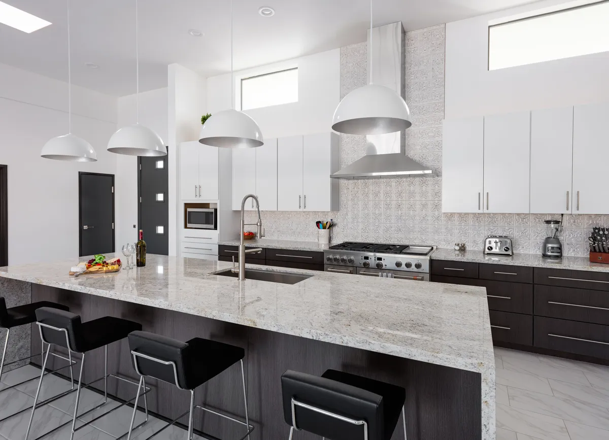 A spacious, modern kitchen featuring a large central island, sleek cabinetry, and high-end appliances. The space is bathed in natural light, with ample room for group cooking, meal prep, or socializing. The sophisticated design signals both functionality and luxury.